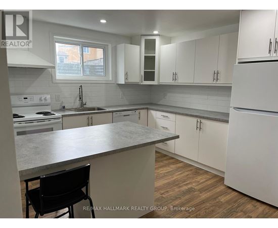 A kitchen with white cabinets and a marble countertop.