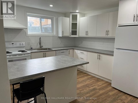 A kitchen with white cabinets and a marble countertop.