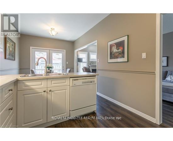 A kitchen with a sink, stove, and cabinets.
