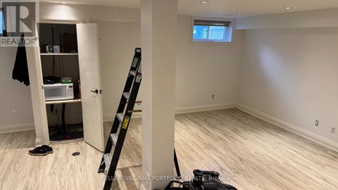 A room with a ladder and a pair of shoes on the floor.