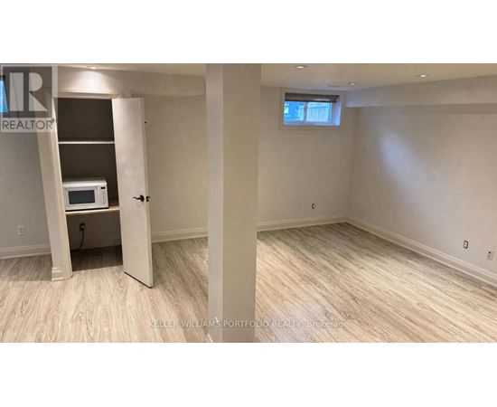 A room with a microwave and a window.