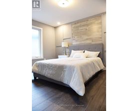 A bedroom with a large bed and a wooden headboard.