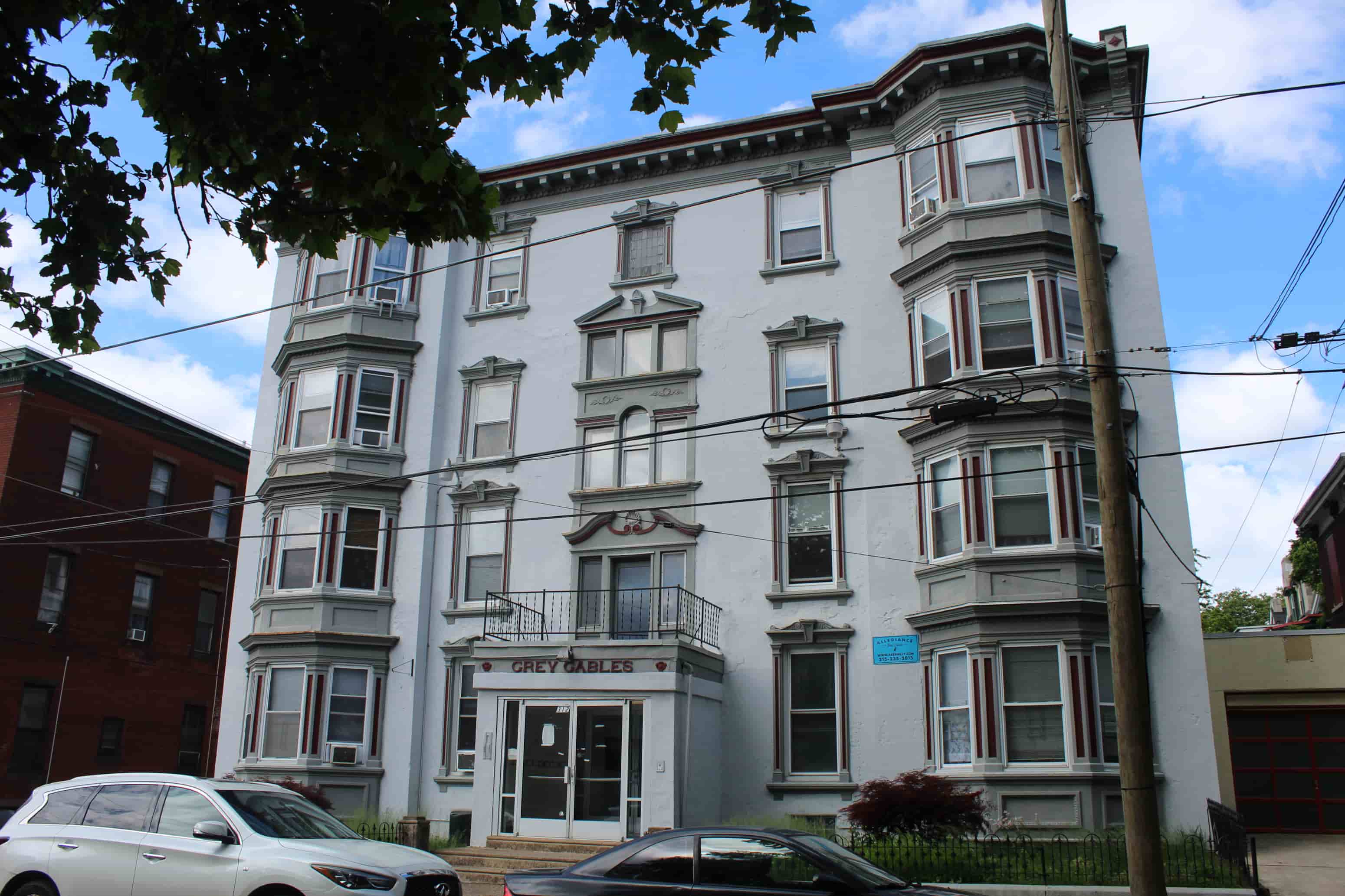 A white building with a balcony and a sign that says "Greyhound" on it.