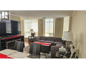 A living room with a grey couch, a red table, and a television.