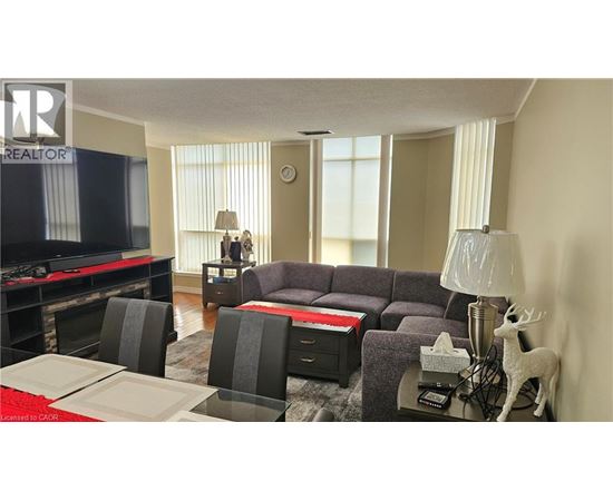 A living room with a grey couch, a red table, and a television.