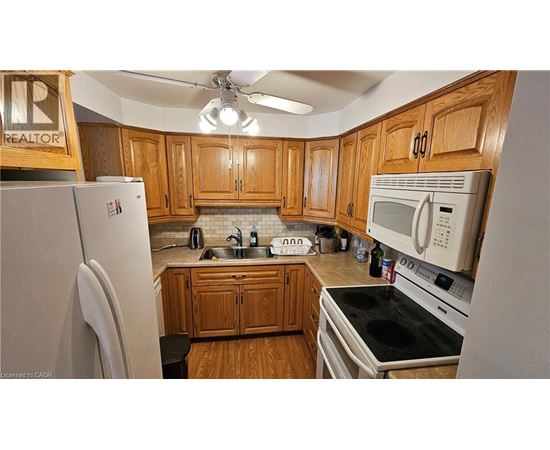 A kitchen with wooden cabinets and a white fridge.
