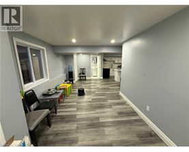 A room with a grey floor and a white wall with a window.