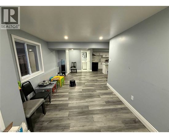 A room with a grey floor and a white wall with a window.