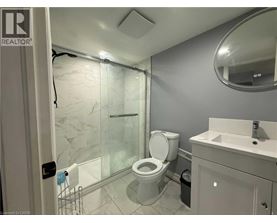 A bathroom with a toilet, sink, and shower.