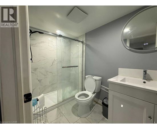 A bathroom with a toilet, sink, and shower.