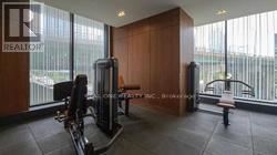 A gym room with a treadmill, weights and a bench.