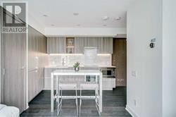 A white dining table with four chairs is in a modern kitchen.