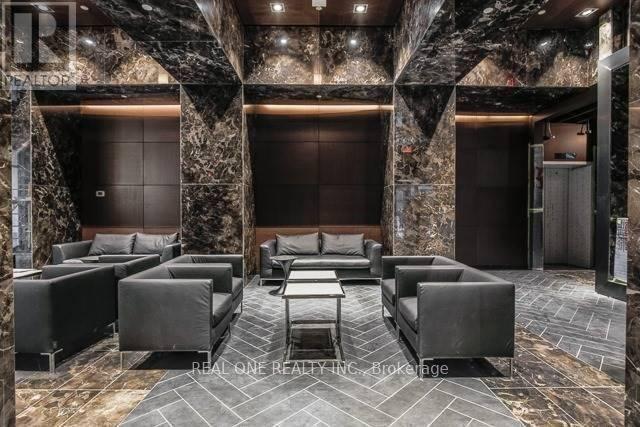 A luxurious room with a stone wall and black furniture.
