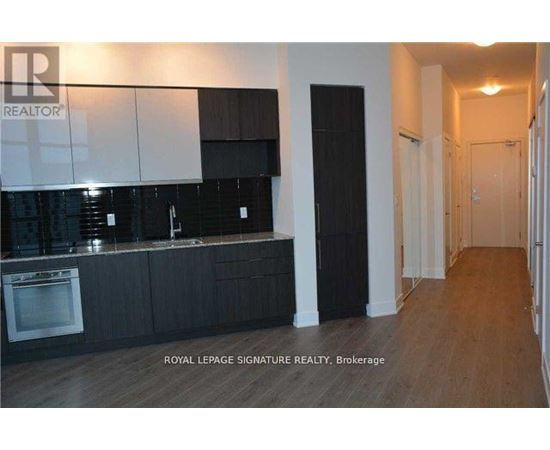 A kitchen with black cabinets and a white wall.