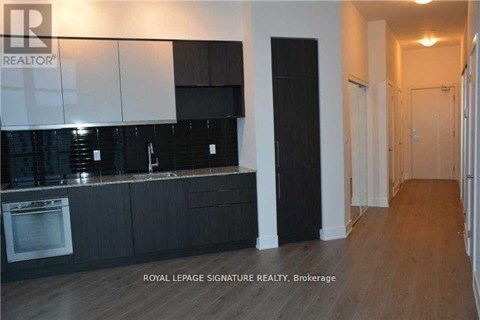 A kitchen with black cabinets and a white wall.