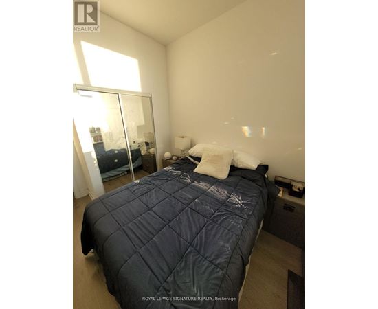 A bedroom with a large bed and a window.