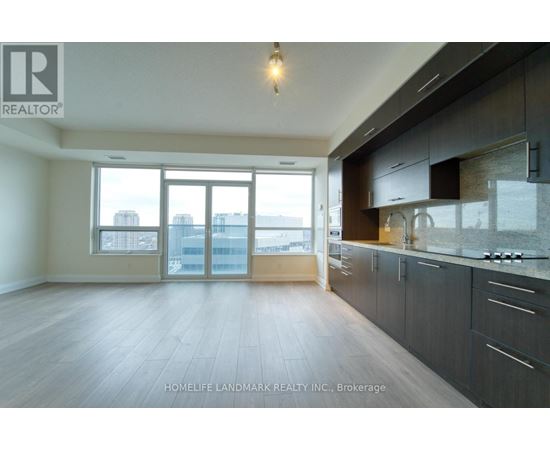 A spacious kitchen with dark wood cabinets and a large window overlooking the city.