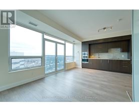 A spacious living room with a view of the cityscape outside the large windows.