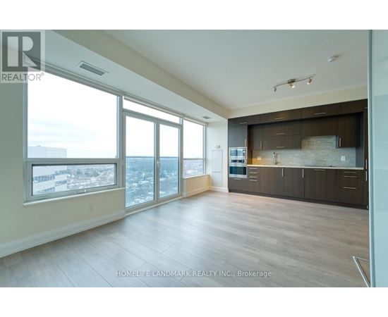 A spacious living room with a view of the cityscape outside the large windows.