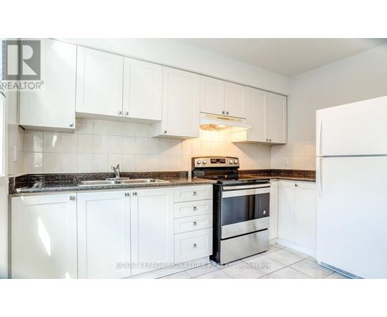 A kitchen with white cabinets and a black stove top oven.