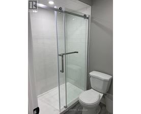 A white toilet in a bathroom with a glass shower door.