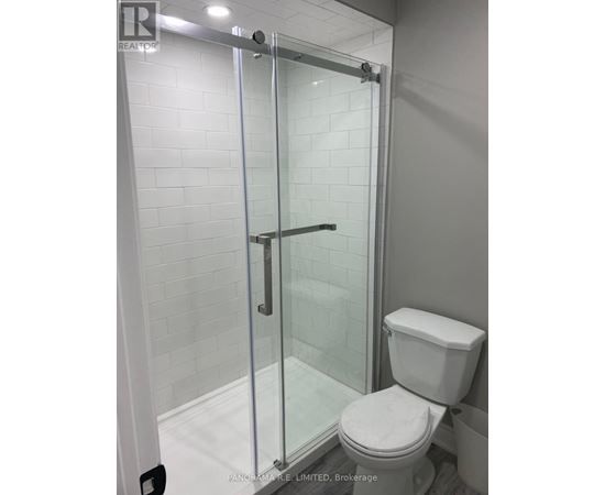 A white toilet in a bathroom with a glass shower door.