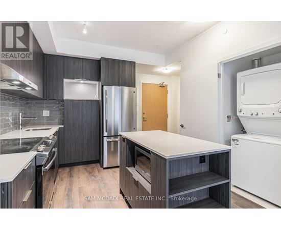 A kitchen with a refrigerator, oven, and dishwasher.