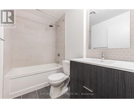 A bathroom with a white tub, toilet, and sink.