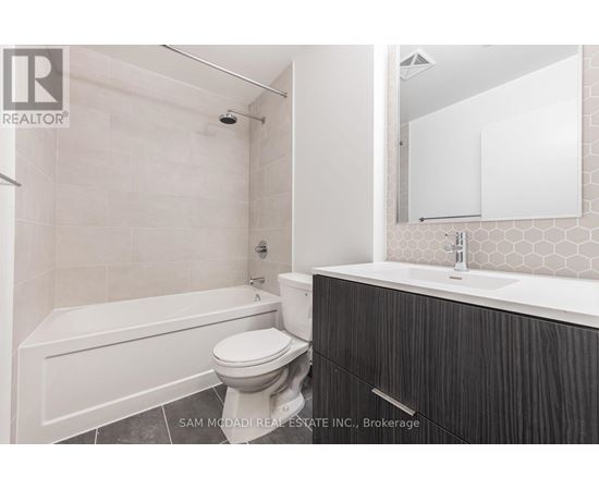 A bathroom with a white tub, toilet, and sink.