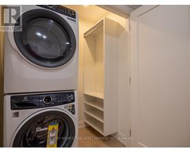 A white washing machine is in a small laundry room.