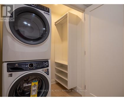A white washing machine is in a small laundry room.