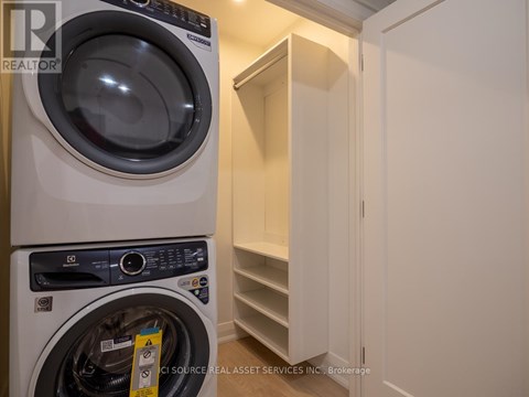 A white washing machine is in a small laundry room.