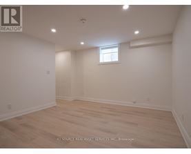A room with a window and wooden flooring.