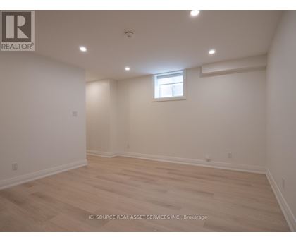 A room with a window and wooden flooring.
