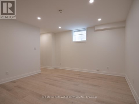 A room with a window and wooden flooring.