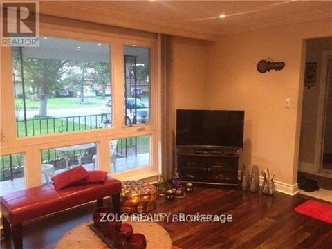 A living room with a red couch and a television.