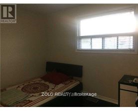 A bedroom with a bed, nightstand, and window with blinds.