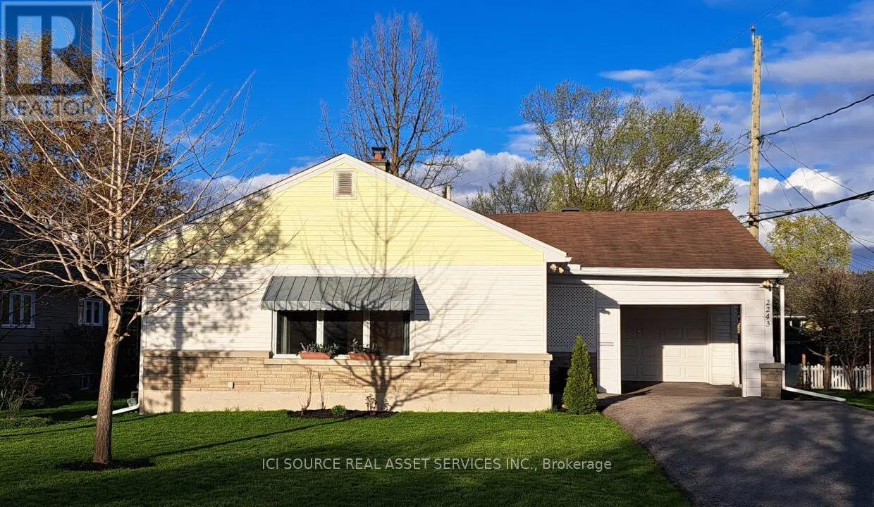 A house with a yellow front and a garage.