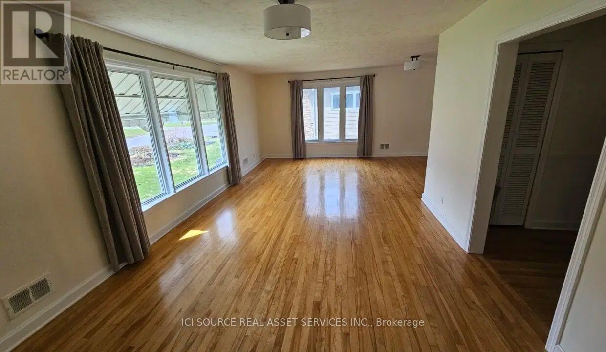 A room with wooden floors and a large window.