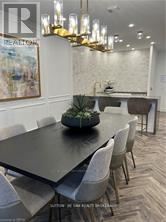 A dining room with a large table and chairs.