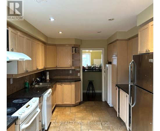 A kitchen with wooden cabinets and black countertops.