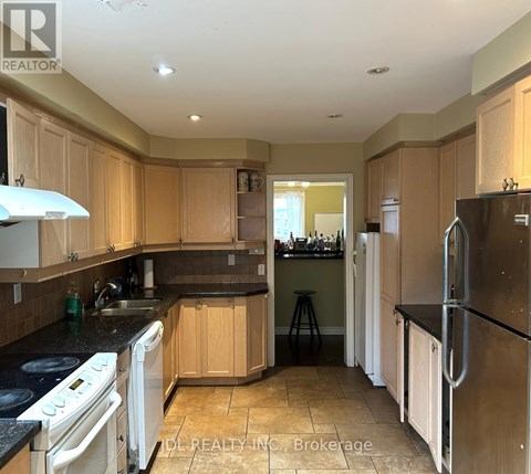 A kitchen with wooden cabinets and black countertops.