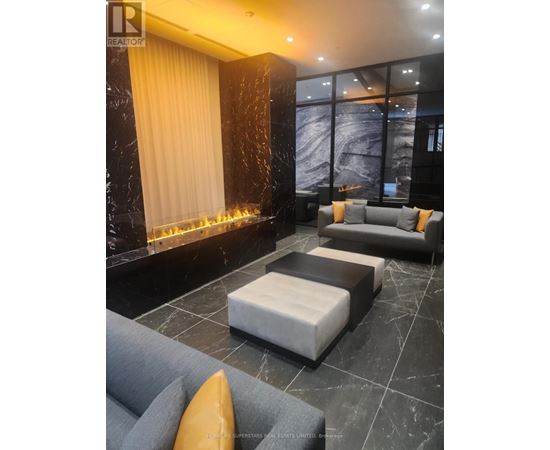 A living room with a grey sofa and a fireplace.