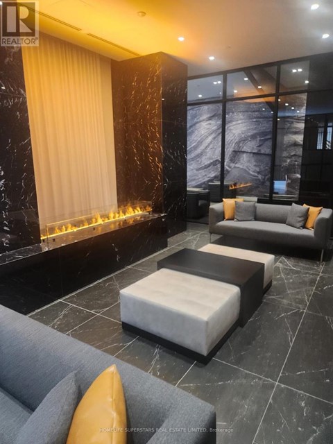 A living room with a grey sofa and a fireplace.