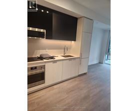A modern kitchen with white cabinets and a stainless steel oven.