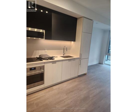 A modern kitchen with white cabinets and a stainless steel oven.