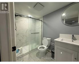 A bathroom with a toilet, sink, and shower.