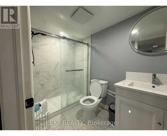A bathroom with a toilet, sink, and shower.