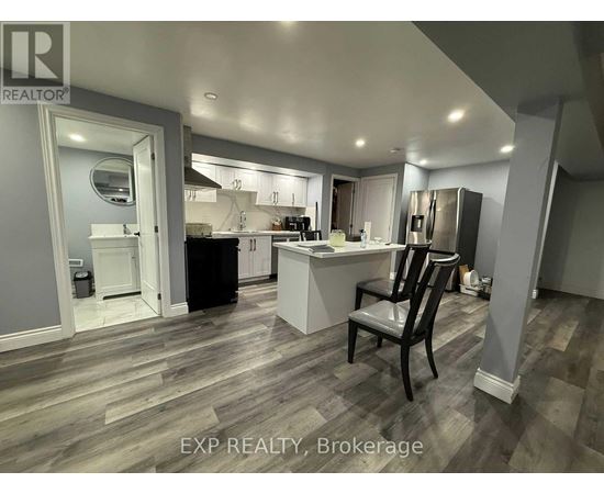 A kitchen with a black chair in the middle of the room.