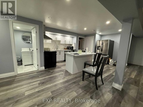 A kitchen with a black chair in the middle of the room.